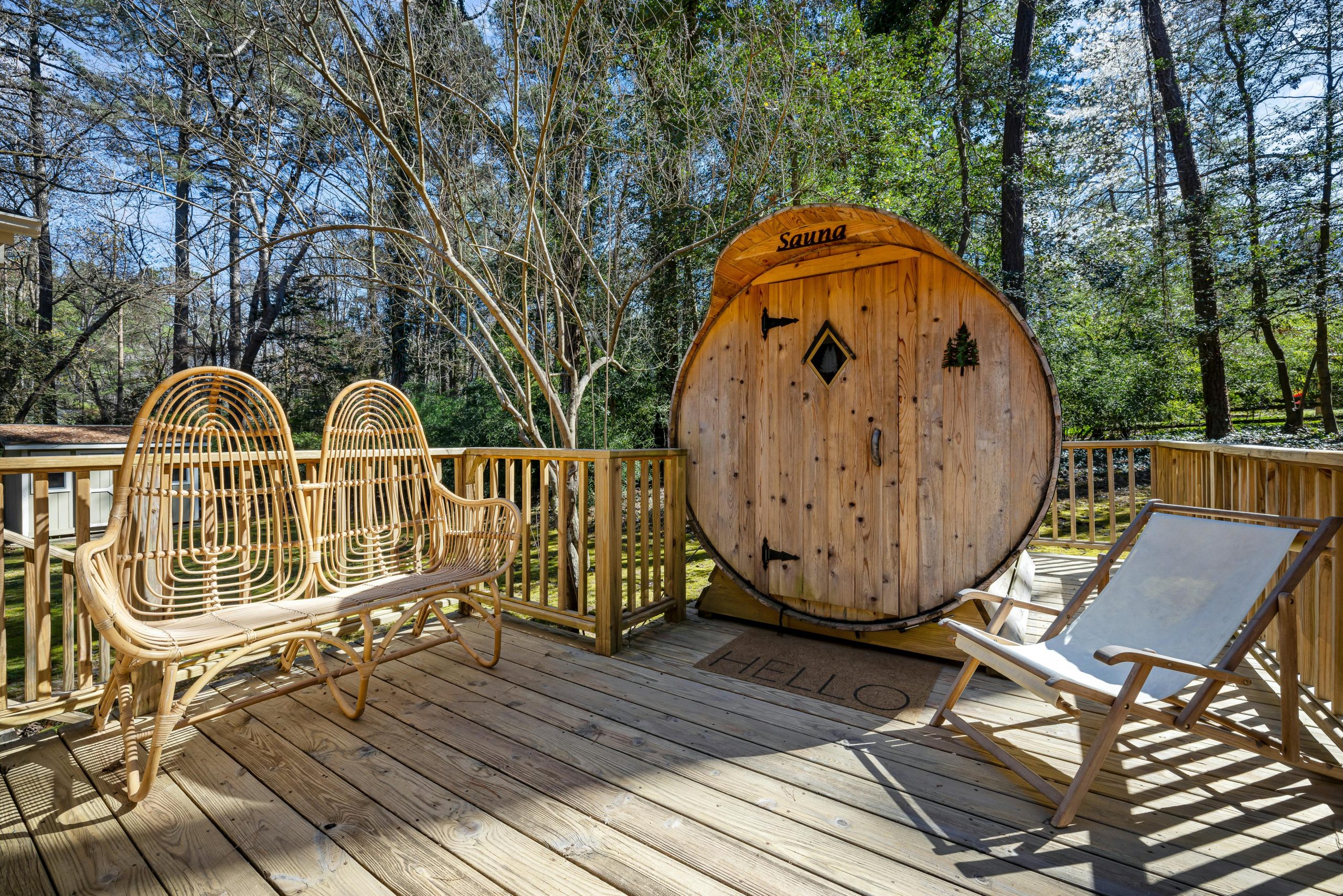 Home A peaceful outdoor terrace with a wooden sauna surrounded by tall trees, perfect for relaxation.